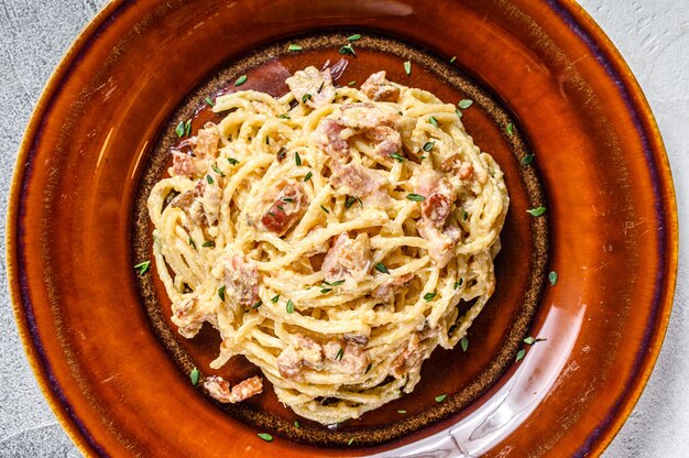 Pasta italiana Spaghetti Carbonara con tocino, queso parmesano duro y salsa de crema.