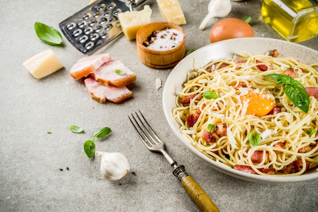 Pasta italiana tradicional, spaghetti carbonara con tocino, salsa cremosa, queso parmesano, yema de huevo y albahaca fresca