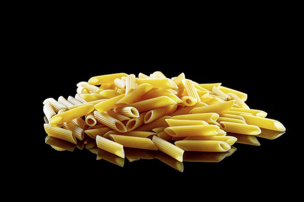 Pasta italienisches Essen federförmige Pasta isolieren auf einem schwarzen Hintergrundfoto