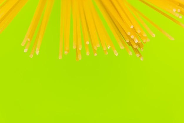 Pasta larga de espagueti amarilla sobre fondo verde Pasta italiana amarilla Comida italiana y concepto de cocina espacio de copia