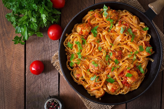 Pasta linguini con albóndigas en salsa de tomate.