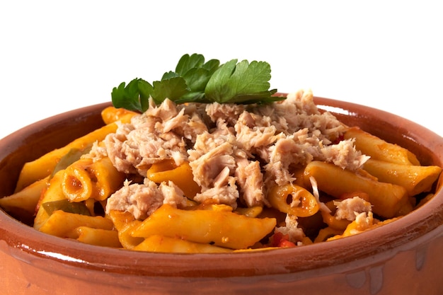 Pasta de macarrones con atún en salsa de tomate servida en un cuenco de arcilla aislado en un fondo blanco