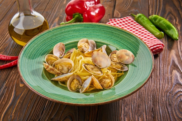 Foto pasta de marisco italiano con almejas sobre fondo de madera