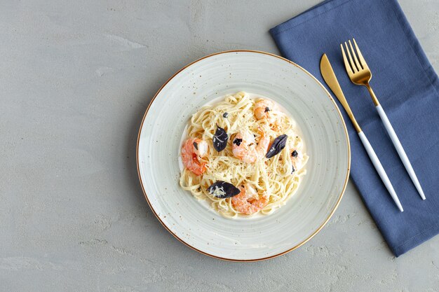 Pasta de mariscos con camarones y salsa de crema servida en un plato