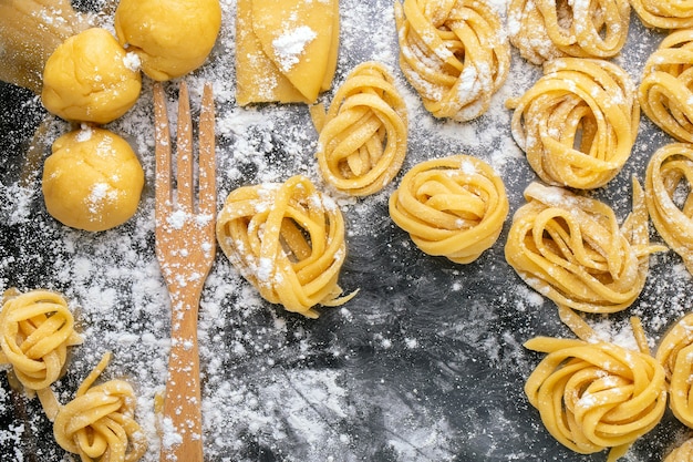 Pasta mit Pasta-Zutaten auf der dunklen Holztisch-Draufsicht