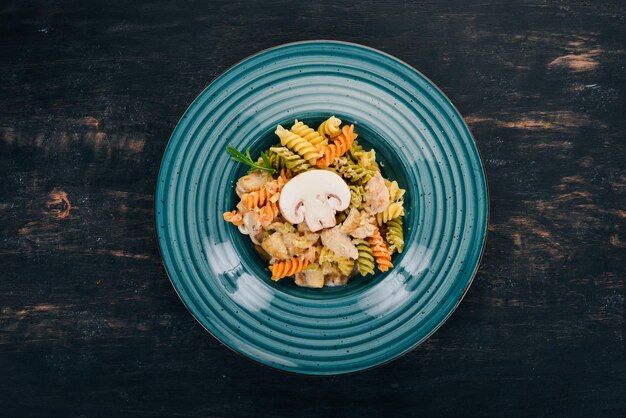 Pasta mit Pilzen und Hähnchen Auf einem hölzernen Hintergrund Italienische Küche Draufsicht Kopieren Sie Platz