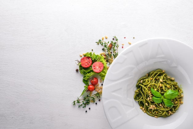 Pasta mit Pinienkernen und Grüns Platte mit dem Wort Paste Draufsicht Freier Platz für Text Auf einem hölzernen Hintergrund