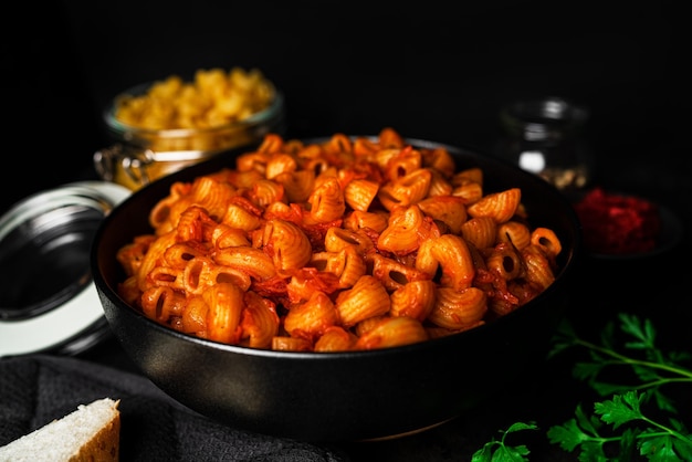 Pasta mit Tomatensauce auf dunklem Hintergrund. Foto in hoher Qualität