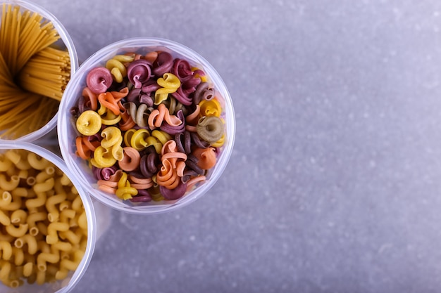 Pasta multicolor con la adición de colorante vegetal natural. En una jarra sobre una mesa de concreto