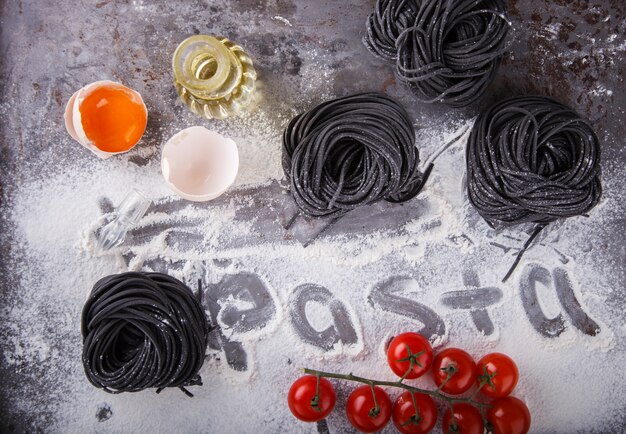 Pasta negra cruda y los ingredientes son caseros, comida italiana espagueti.