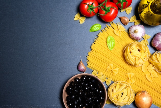 Pasta oder italienische Spaghetti mit Zutaten auf schwarzem Stein Schiefer Hintergrund. Exemplar