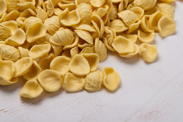 Pasta orecchiette amarillo sobre mesa de madera