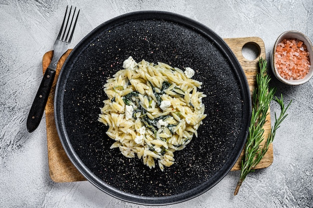 Pasta orzo de espinacas y queso feta en un plato