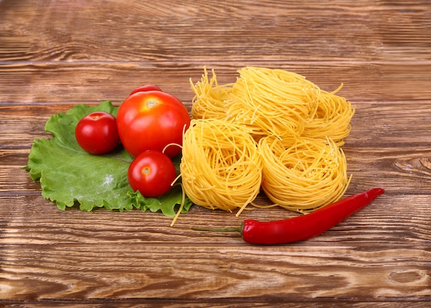 Pasta en la pared de madera con tomate, pimiento, lechuga y pimiento