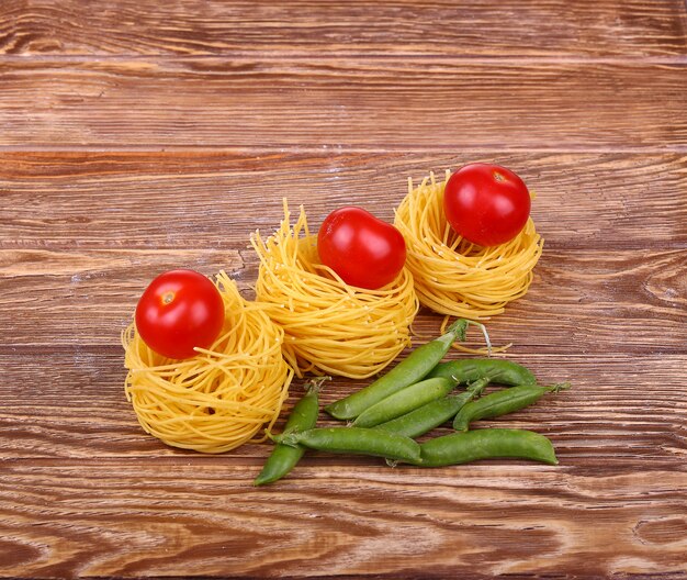 Pasta en la pared de madera con tomate, pimiento, lechuga y pimiento