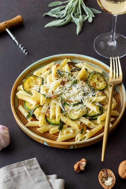 Pasta penne con calabacín, salvia, nueces y queso parmesano. Alimentación saludable. Comida vegetariana. Comida italiana.