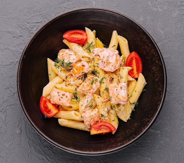 Pasta penne carbonara con salmón en un tazón