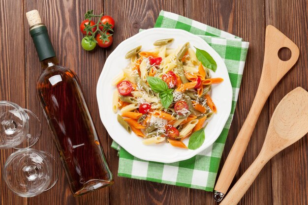 Pasta penne colorida y vino blanco