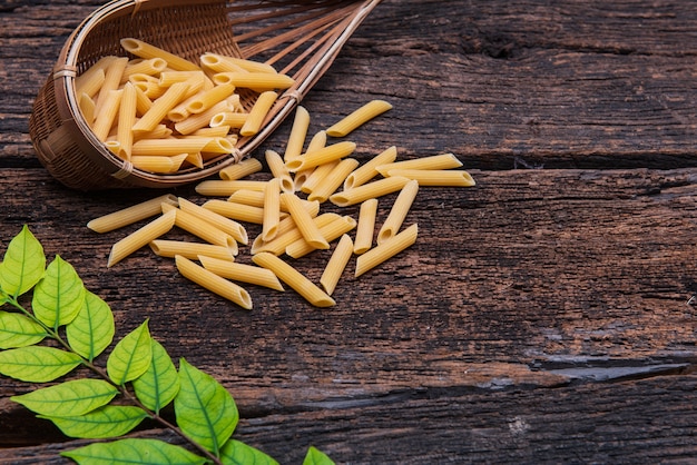 Pasta Penne en el fondo de madera vieja