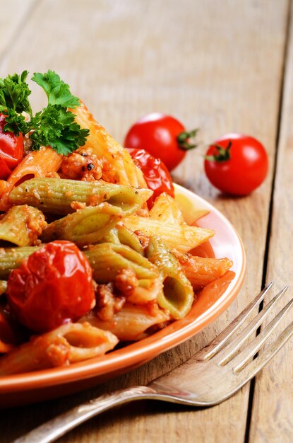 Pasta penne con salsa boloñesa de ternera con tomate en la mesa de la cocina