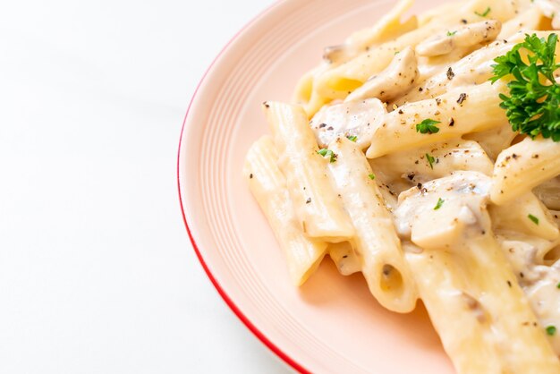 pasta penne salsa de crema carbonara con champiñones - estilo de comida italiana