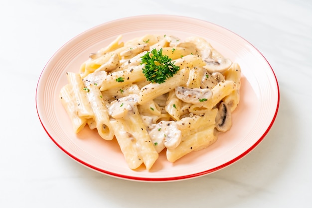 pasta penne salsa de crema carbonara con champiñones - estilo de comida italiana