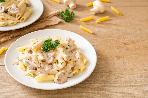 pasta penne salsa de crema carbonara con champiñones - estilo de comida italiana