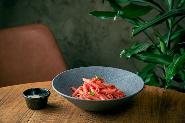 Pasta penne con salsa de tomate y albahaca en un plato gris. cocina italiana