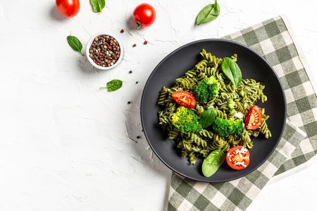 Pasta penne vegetariana con brócoli, salsa de aguacate, hojas de espinaca y tomates cherry. Plato italiano