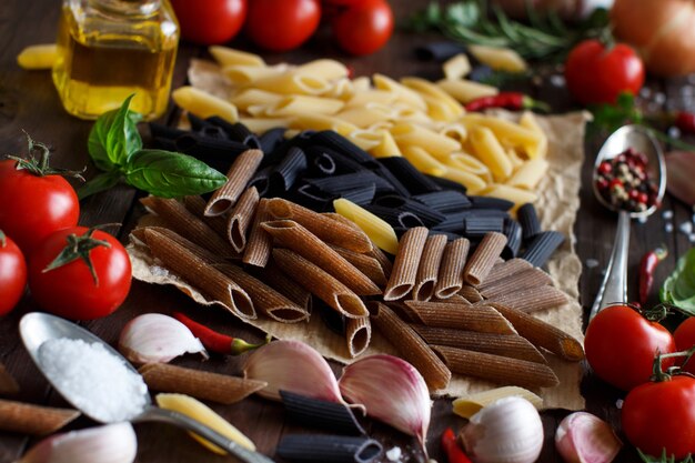 Pasta penne con verduras, hierbas y aceite de oliva en la mesa de madera