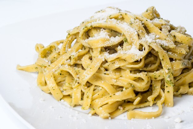 Pasta con pesto en plato blanco