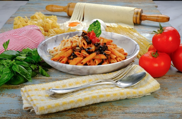 Foto pasta en el plato sobre la mesa salsa de tomate arabiata salsa boloñesa penne, etc.