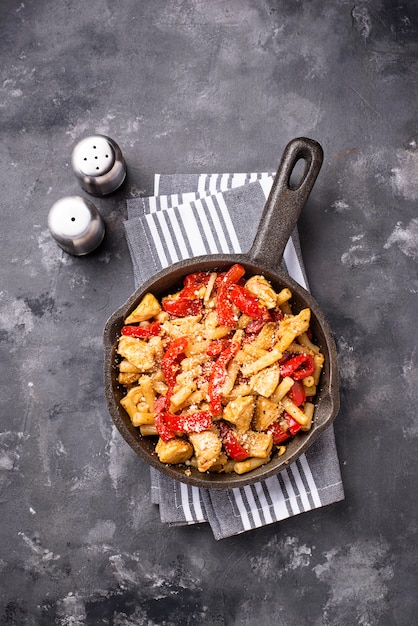 Pasta con pollo y pimiento en salsa de tomate.