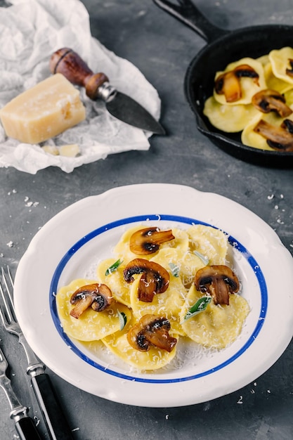 Pasta de ravioli de cocina italiana con champiñones y queso parmesano