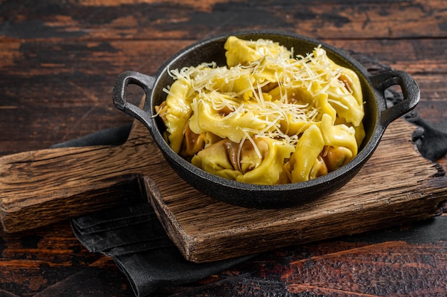 Pasta Ravioli con Mozzarella, Parmesano y Tomate. Fondo de madera. Vista superior.