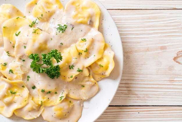 Foto pasta de ravioli con salsa de crema de hongos y queso