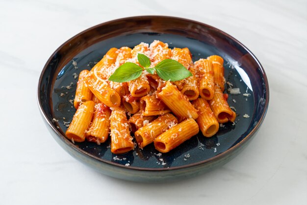 Foto pasta de rigatoni con salsa de tomate y queso