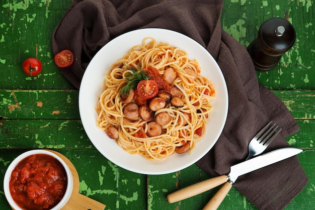 Pasta con salchichas y salsa de tomate sobre un fondo rústico, vista superior