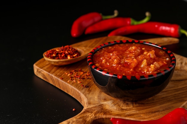 Pasta de salsa de ají picante tradicional del Magreb harissa sobre superficie oscura, Túnez y cocina árabe