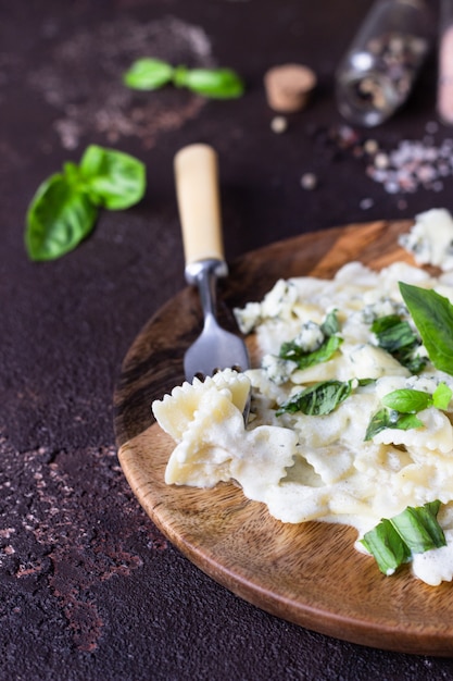 Foto pasta con salsa cremosa con albahaca y queso gorgonzola.