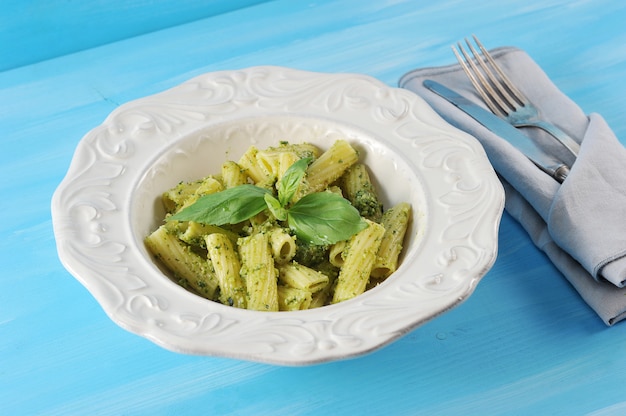 Pasta con salsa de pesto y albahaca en plato