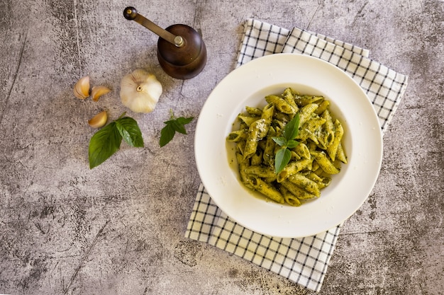 Pasta con salsa pesto casera en la mesa