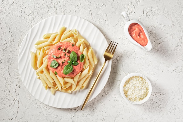 Pasta con salsa rosa, salsa Parma Rosa con Penne en un plato con tenedor dorado, puesta plana