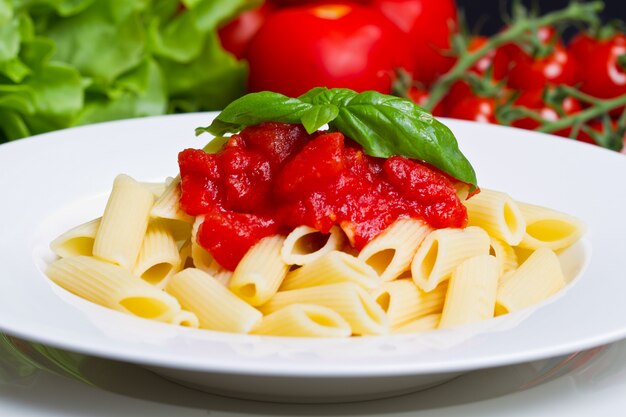 Foto pasta con salsa de tomate y albahaca.