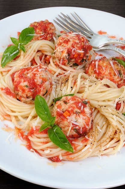 Pasta en salsa de tomate con albóndigas espolvoreadas con parmesano y albahaca