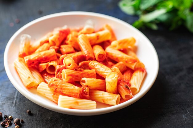 Pasta salsa de tomate plato de macarrones receta clásica en la mesa espacio de copia de aperitivos de comida