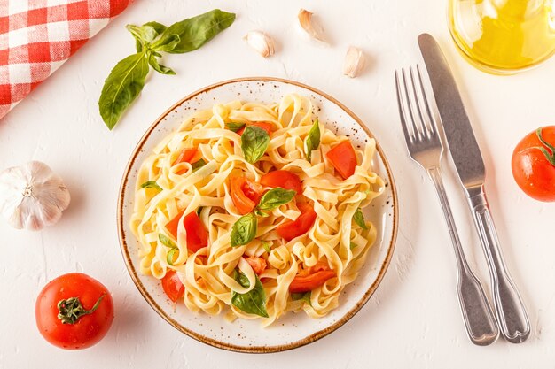 Pasta con salsa de tomate servida con albahaca