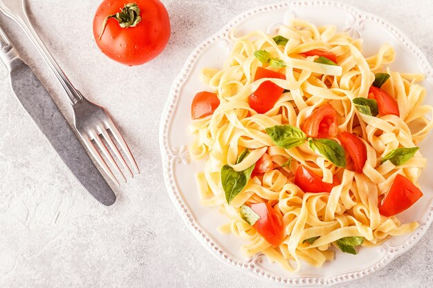 Pasta con salsa de tomate servida con albahaca