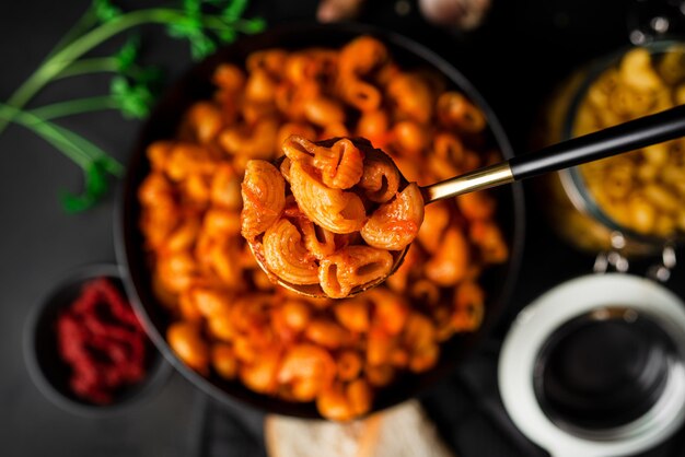 Pasta con salsa de tomate sobre fondo oscuro. Foto de alta calidad