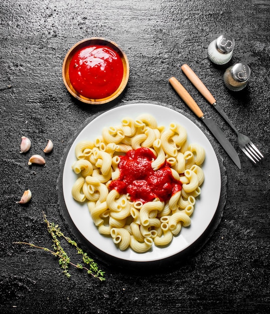 Pasta y salsa de tomate en un tazón con tomillo y especias